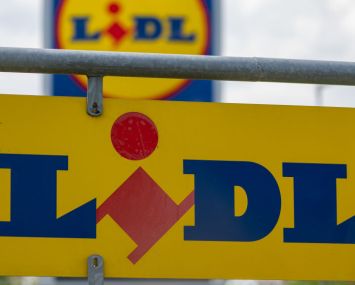 A sign with the logo of the discounter Lidl stands in the parking lot of a branch.