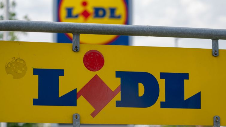 A sign with the logo of the discounter Lidl stands in the parking lot of a branch.