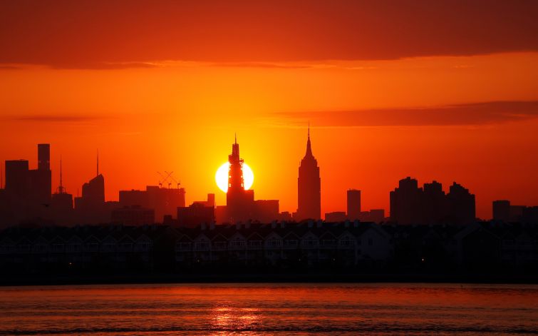 The sun rises behind One Vanderbilt and the Empire State Building in New York City in May 2023.