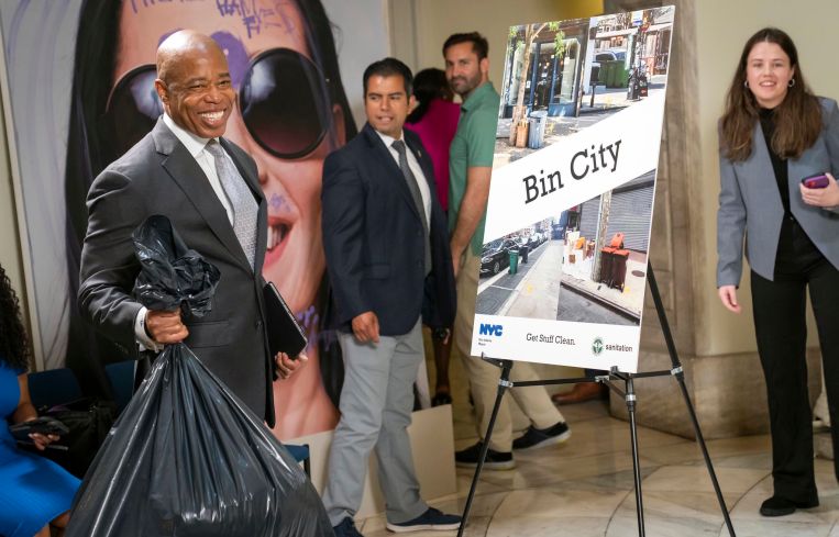 Eric Adams holding a trash bag