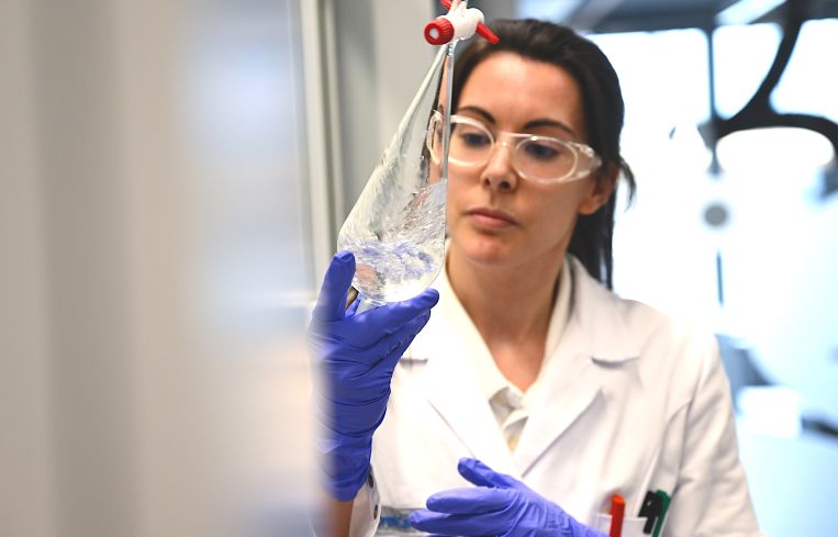 Chemistry lab technician performs a shake-out test for traces of acid in a laboratory of pharmaceutical and technology group Merck.