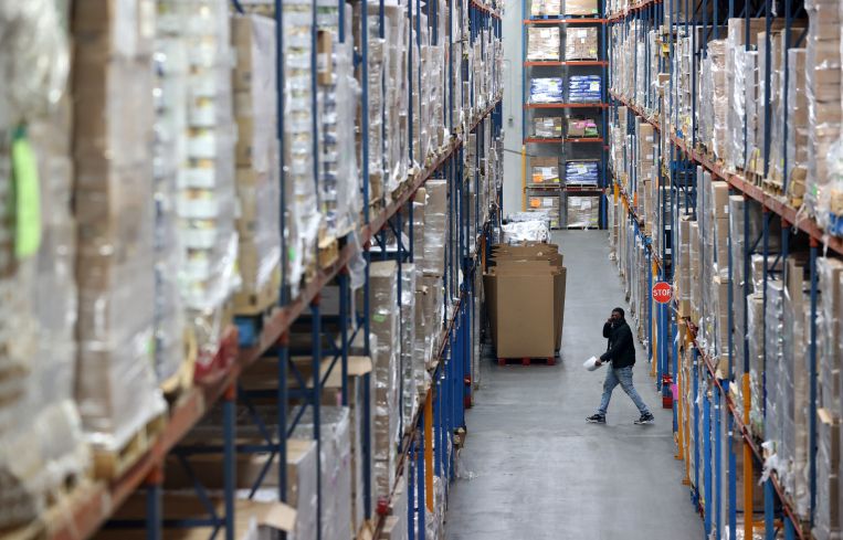 A worker walks through a warehouse.