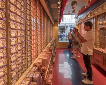 A man taking a photo of sardine cans in a store.