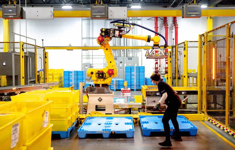 A robot sorts and stacks bins at Amazon fulfillment center in Eastvale, Calif.