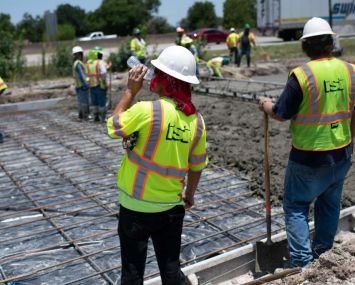 A construction worker takes a sip of water while repairing a road that was damaged from the heat in Houston, Texas on June 27, 2023