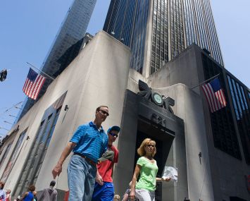 People walking about a building in Manhattan