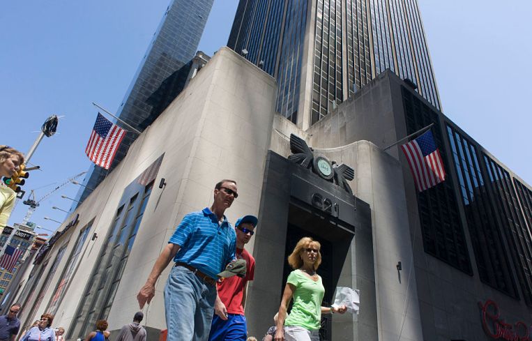 People walking about a building in Manhattan