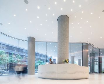 The new lobby at 767 Third Avenue has curved, floor to ceiling glass panels.