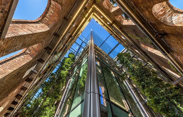 Hanging plants, vines, flowers and fake plants all adorn the steel girders between the new and old facades.