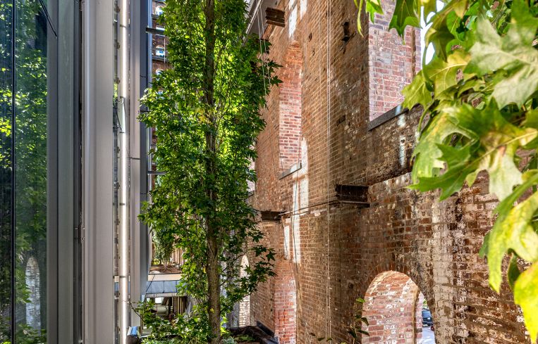 A vertical garden was installed between the old building and the new one, because the exterior of the old building has been left open to the sky and air.
