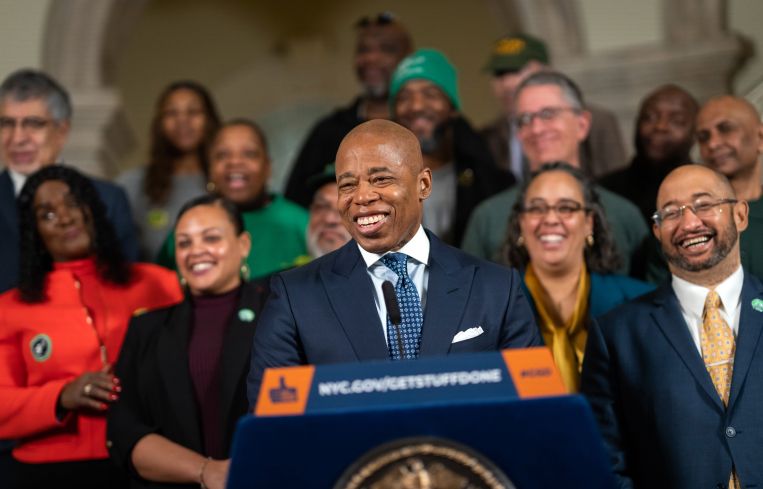 Mayor Eric Adams speaking at a podium.