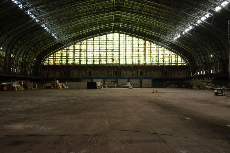 A vast drill hall with a dirt floor.