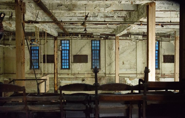 A large room supported by rusty steel columns.