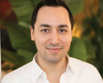 A close shot of a man's head, and he's smiling.