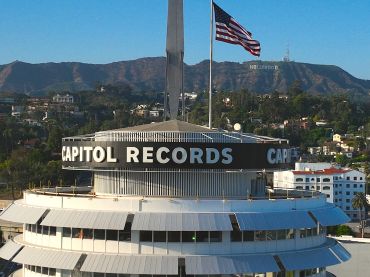 Aerial drone view of the iconic Capitol Records Building and the Hollywood sign.