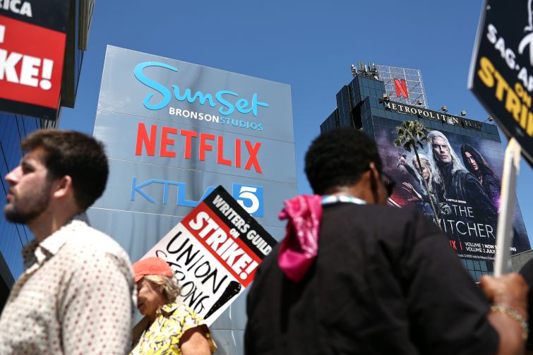SAG-AFTRA members picket with striking WGA workers outside Netflix offices and Sunset Bronson in Los Angeles.