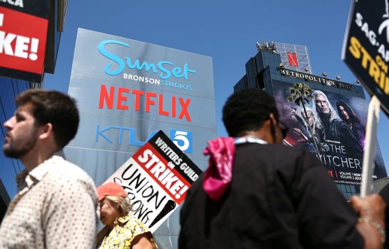 SAG-AFTRA members picket with striking WGA workers outside Netflix offices and Sunset Bronson in Los Angeles.