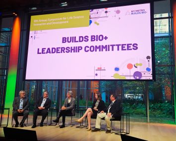 A panel of five people seated on a stage.