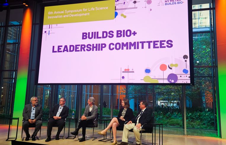 A panel of five people seated on a stage.
