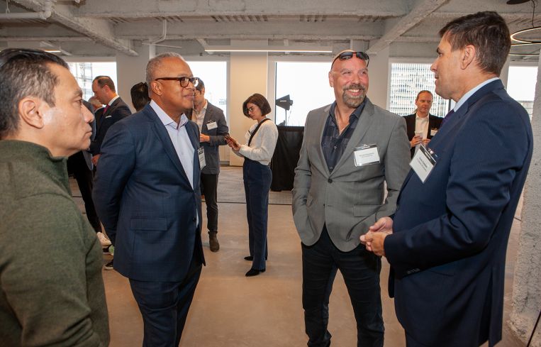 A circle of four men chatting.