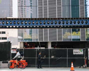 People pass a building where construction is underway for apartments in Downtown L.A.
