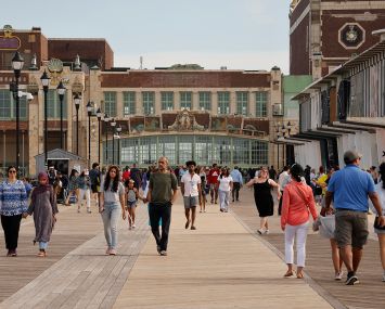 People walk along the boardwalk outside the Asbury Park Convention Hall in Asbury Park, N.J.