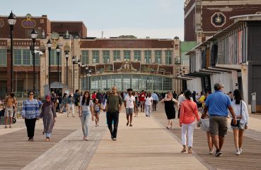 People walk along the boardwalk outside the Asbury Park Convention Hall in Asbury Park, N.J.