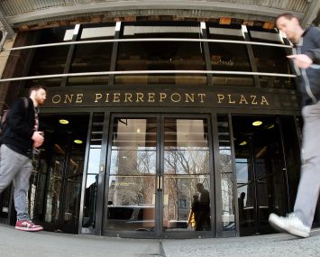 People walk past the main entrance of the 1 Pierrepont Plaza building in Brooklyn, N.Y.