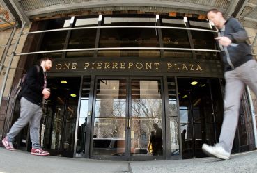 People walk past the main entrance of the 1 Pierrepont Plaza building in Brooklyn, N.Y.