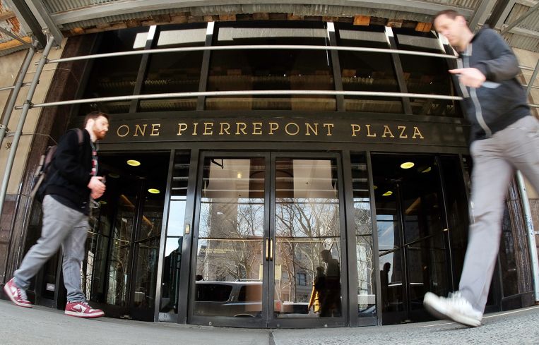 People walk past the main entrance of the 1 Pierrepont Plaza building in Brooklyn, N.Y.