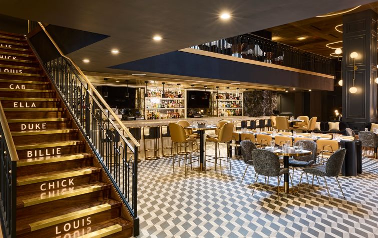 The fifth floor has a restaurant, lounge and conference center designed with Roaring 20s-inspired blue, black and gold decor. A stair to an upper mezzanine has the names of famous jazz musicians. 