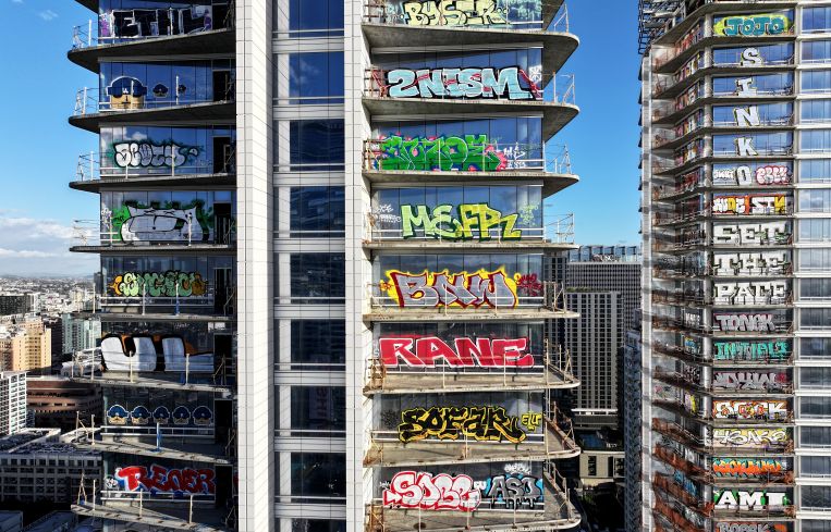 An aerial view of graffiti spray painted by taggers on at least 27 stories of an unfinished skyscraper development downtown, with Cryto.com Arena visible in February. Construction of the $1 billion Oceanwide Plaza luxury real estate development stalled in 2019 after a China-based developer ran out of funding leaving the three-tower project uncompleted. The project is located across the street from the Crypto.com Arena where the Grammy Awards will be held on February 4.