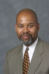 A man in a suit smiling.