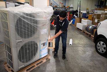 A worker examines a heat pump in his workshop in western France.