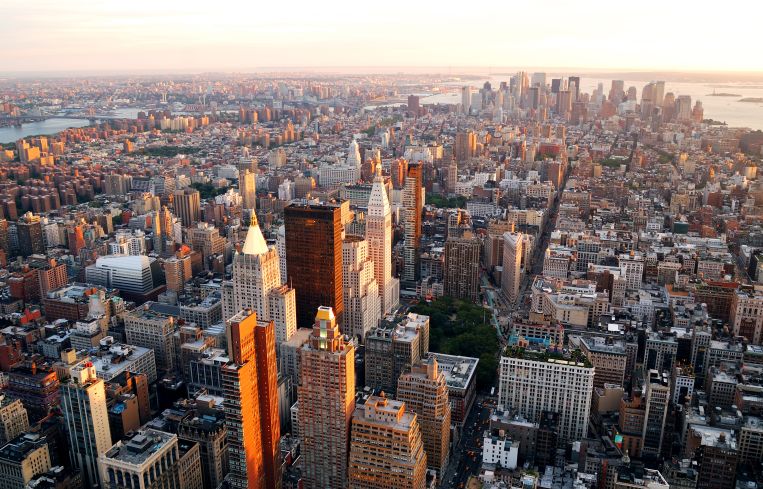 An aerial view of a big city with lots of buildings, at sunset.
