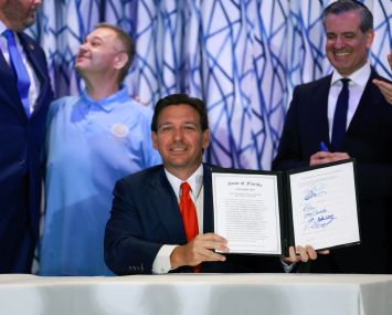 Florida Gov. Ron DeSantis signs Florida House Bill 1365 during a news conference held at the Santorini by Georgios restaurant on March 20, 2024 in Miami Beach, Florida.