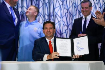 Florida Gov. Ron DeSantis signs Florida House Bill 1365 during a news conference held at the Santorini by Georgios restaurant on March 20, 2024 in Miami Beach, Florida.