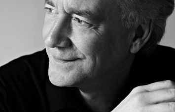A man in a dark knit top.