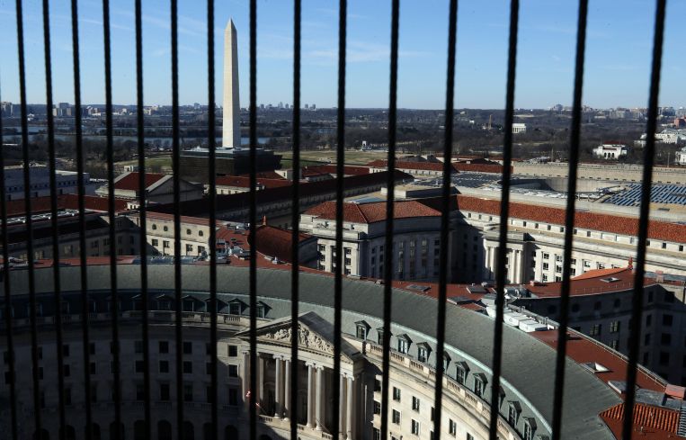 A view of the Washington Monument seen between wires that cover the windows on the observation deck of the Old Post Office Tower in Washington, DC.