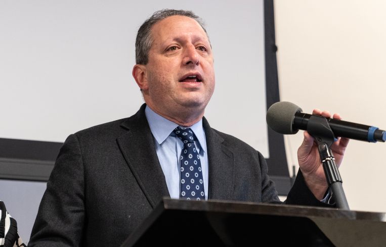 A man in a suit at a podium.