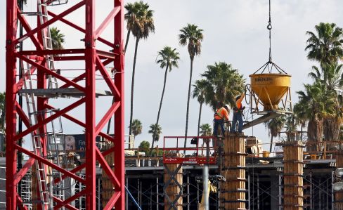 Construction workers build a mixed-use apartment complex in Los Angeles.