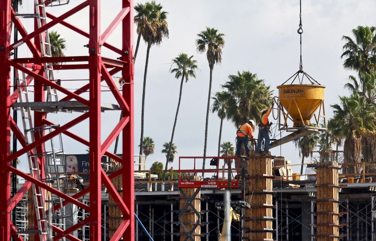 Construction workers build a mixed-use apartment complex in Los Angeles.