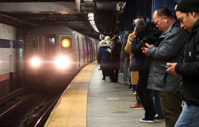 Passengers wait for a train at Columbus Circle Station in New York City