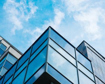 Panoramic wide angle view to steel blue background of glass high rise building skyscrapers in modern futuristic downtown at night Business concept of successful industrial architecture.