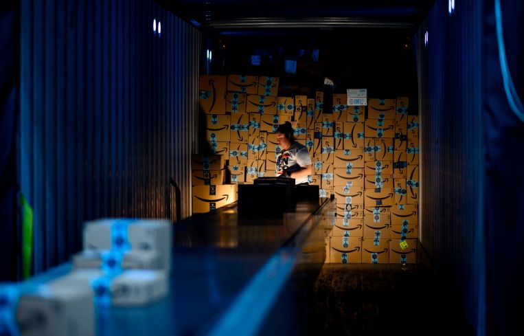 A woman works at in a delivery truck at an Amazon fulfillment center.