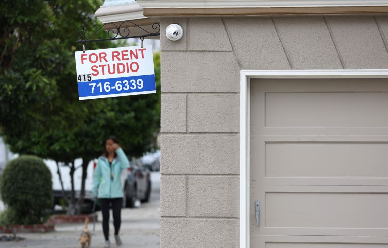 A sign is posted in front of an apartment building with available rentals.