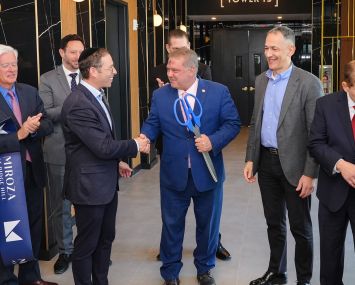 Jack Klein shakes hands with Yonkers Mayor Mike Spano (holding scissors) with Azorim CEO Ron Avidan to their right at the ribbon cutting for tower 3 of Miroza at Ridge Hill.