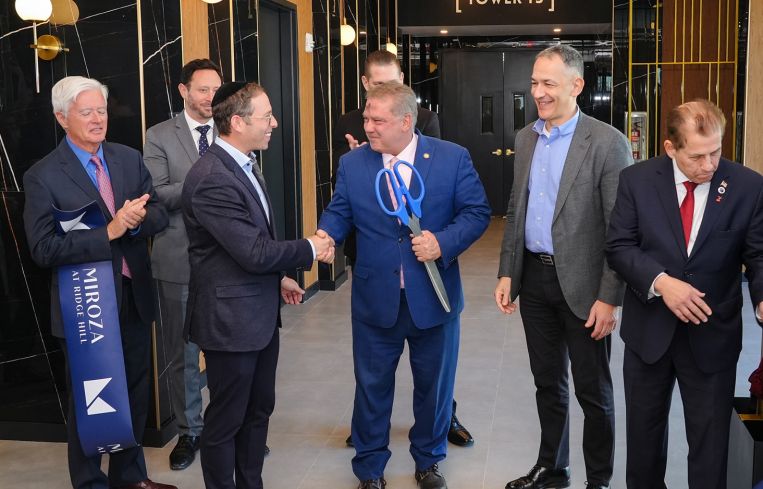 Jack Klein shakes hands with Yonkers Mayor Mike Spano (holding scissors) with Azorim CEO Ron Avidan to their right at the ribbon cutting for tower 3 of Miroza at Ridge Hill.