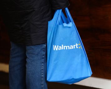 A shopper carrying a Walmart bag.