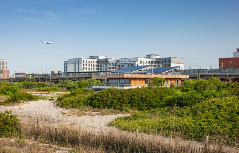 A wide view of the Welcome Center amid an large undeveloped area of dunes and beach grass.